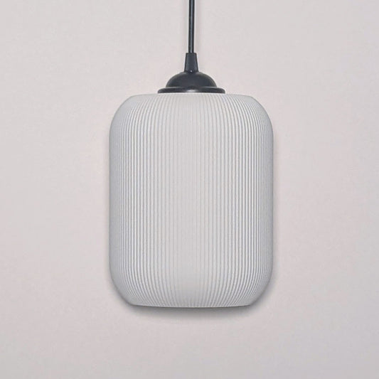 The Cumulis Pendant Light by Dryft Home showcases a modern design with a cylindrical textured white shade made from sustainable materials and a sleek black fixture, elegantly set against a plain white background.