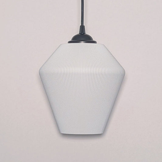 Dryft Homes Inversis Pendant Light showcases a modern geometric white design suspended by a black cord. Crafted sustainably with a 3D printed lampshade, its subtle ribbed texture adds a stylish, minimalist touch to any plain white wall.