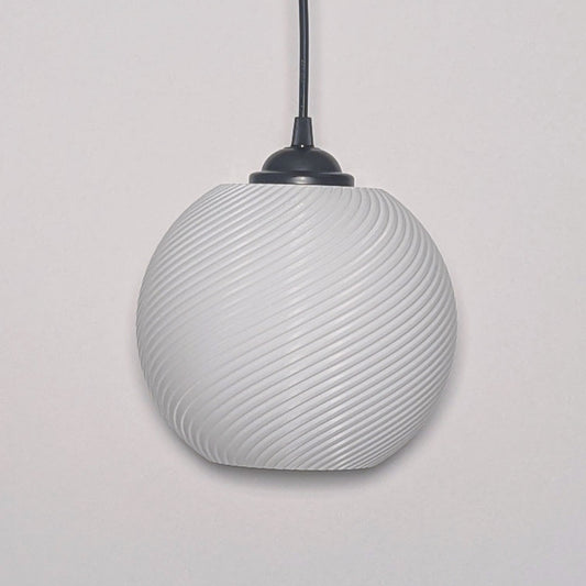 The Vortice Pendant Light by Dryft Home features a textured spiraling design, 3D printed from biodegradable PLA plastic. It hangs from a black cord against a plain white backdrop.